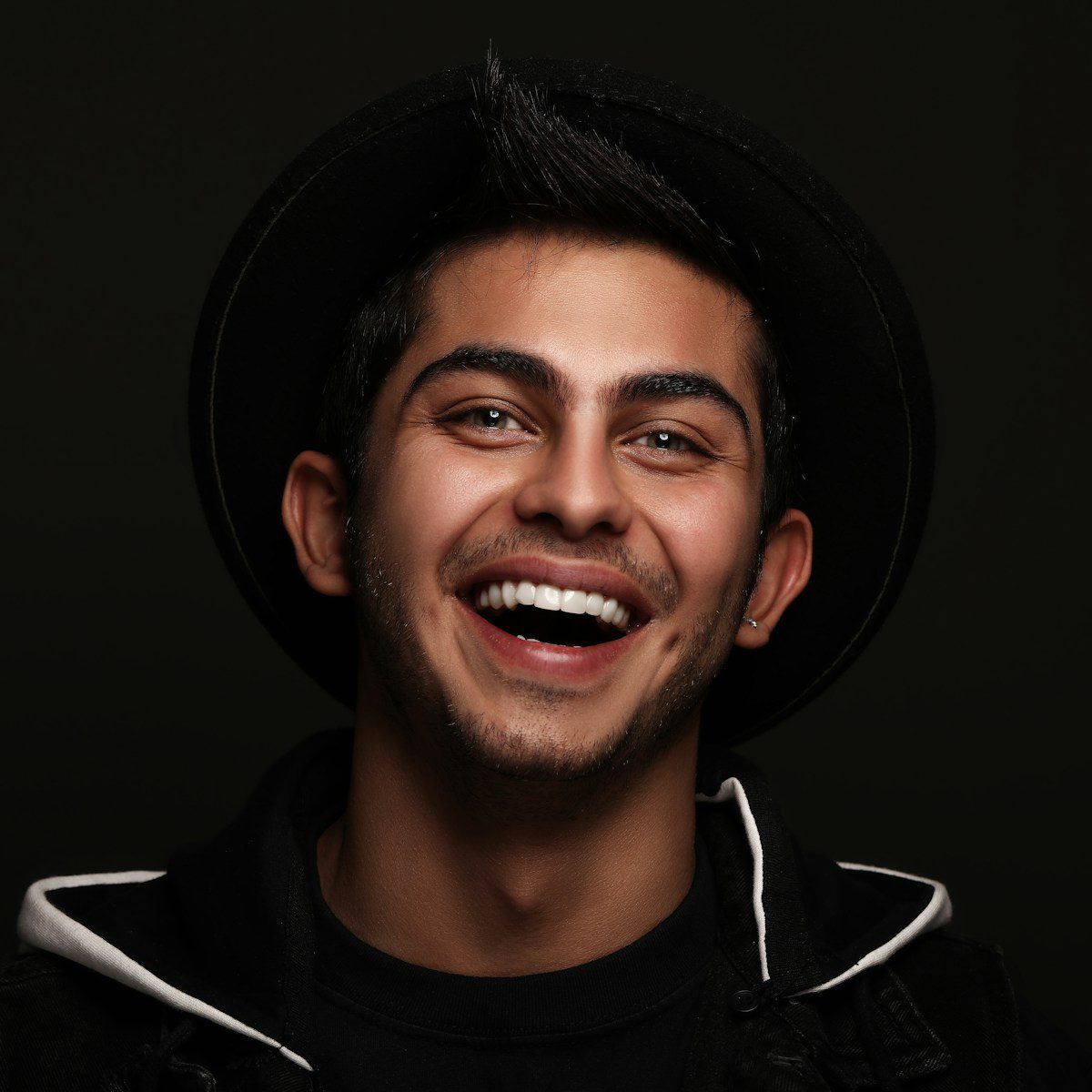 Photo by Amir Seilsepour man in black and white nike zip up jacket smiling