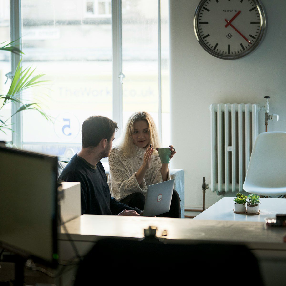 Photo by Adomas Aleno man and woman sitting on chair in front of silver macbook